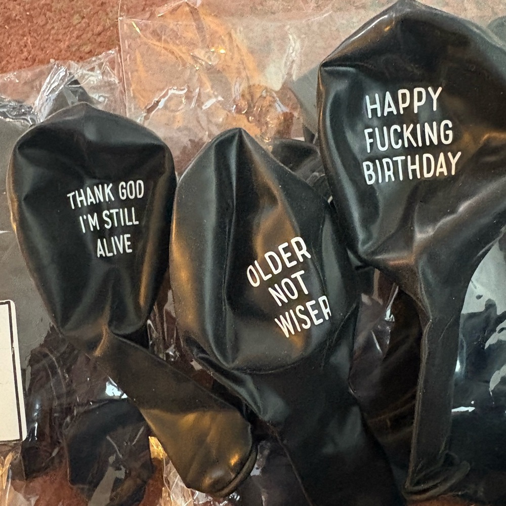 Black Party Balloons with Humorous Text and Paper Fan Decor